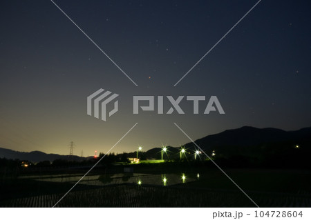 北杜市武川町、夜の始め頃、舞鶴橋の上に昇った赤い星アンタレス。水田に映る外灯 104728604