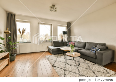 a living room with a couch and coffee table in front of the window looking out to the cityscape 104729090