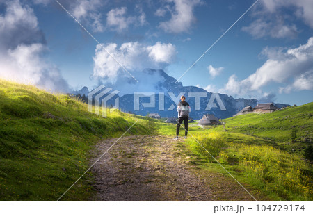 Girl on the rural road with yellow flowers and green grass 104729174