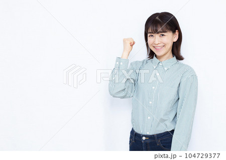 白い背景の前でガッツポーズをしている30代の女性 白い背景の前でガッツポーズをしている30代の女性 104729377