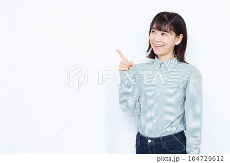 白い背景の前で人差し指を立てる30代の女性 104729612