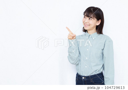白い背景の前で人差し指を立てる30代の女性 104729613