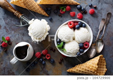 Vanilla ice cream scoops in a bowl with fresh berries 104729900