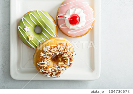 Assorted glazed fried donuts on a plate 104730678