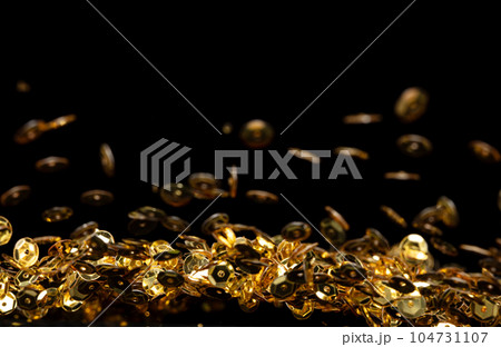 Explosion metallic gold glitter sequin sparkle. Golden Glitter sequin spark blink celebrate, blur foil explode in air, fly throw gold particle. Black background isolated, selective focus Blur bokeh 104731107