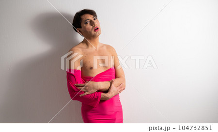 Homosexual in a pink female dress. A man in make-up. 104732851