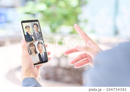 スマホでビデオ会議をしているビジネスパーソンの手元 104734391