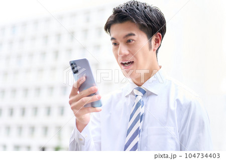 スマホの画面を見て口を開けるビジネスパーソン スマホの画面を見て口を開けるビジネスパーソン 104734403