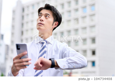 時間と場所を確認するワイシャツ姿のビジネスパーソン 104734408