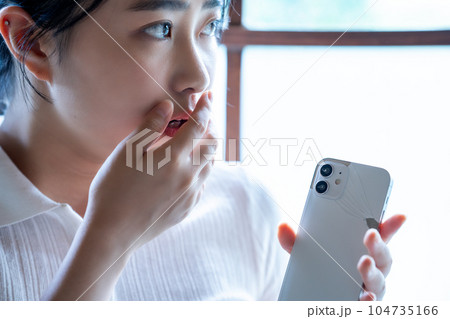 スマホを壊してショックを受ける若い女性 スマホを壊してショックを受ける若い女性 104735166