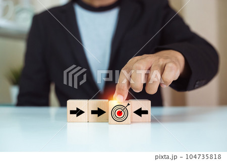 Businessman holding wood cube block with goal icon and arrow. Connection partner to goal concept 104735818
