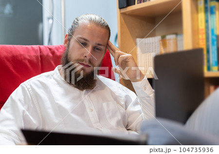 Businessman caucasian with beard using laptop. Sitting and work in book corner. 104735936