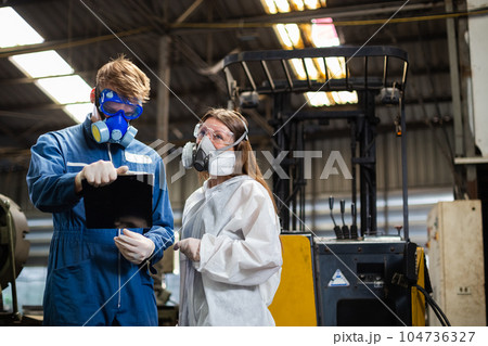 Team inspector wearing chemical protective mask and hazmat suit examining chemistry in industrial. 104736327