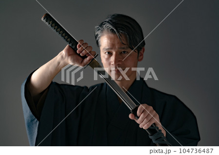 日本刀を持つ男性　黒バック 104736487