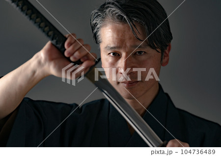 日本刀を持つ男性　黒バック 104736489