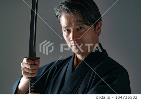 日本刀を持つ男性　黒バック 104736502