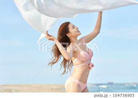 young woman in swimsuit posing on beach 104736905