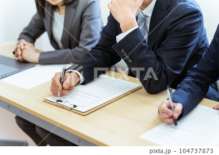 履歴書を見ながら審査する面接官 104737873