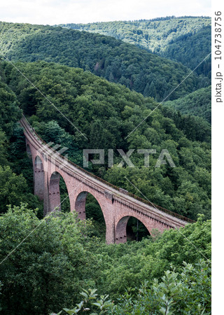 old arch Bridge railway viaduct between hills in the green Forest Germany trees old arch Bridge railway viaduct between hills in the green Forest Germany trees 104738756