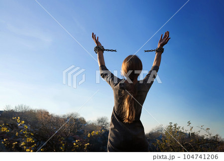 Tied hands raised to the sky 104741206