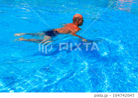 Handsome man relaxing in the swimming pool 104742045