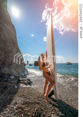 Woman sup sea travel in black bikini. Portrait of a happy girl on the background of a surfboard in the sea on a sunny summer day 104744315