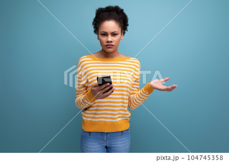 confused brunette brown-haired young woman with a mobile phone 104745358