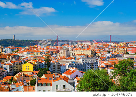 Lisbon famous view from Miradouro dos Barros tourist viewpoint over Alfama old city district, 25th of April Bridge and Christ the King statue. Lisbon, Portugal. 104746675