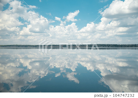 Fantastic landscape. Clouds and the river. Mirror water. blue lake with cloudy sky, nature series. road in clouds 104747232
