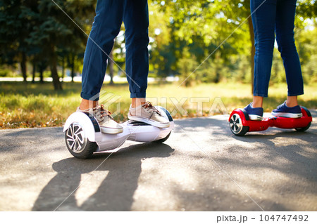 Young man and woman riding on the Hoverboard in the park. content technologies. a new movement. 104747492