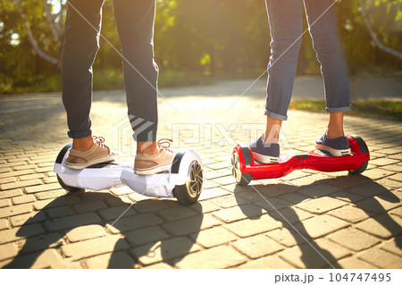 Young man and woman riding on the Hoverboard in the park. content technologies. a new movement. 104747495