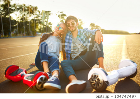 Young man and woman riding on the Hoverboard in the park. content technologies. a new movement. 104747497