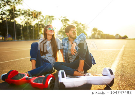 Young man and woman riding on the Hoverboard in the park. content technologies. a new movement. 104747498