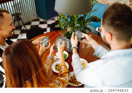 Happy friends having a great time in cafe. Young people sitting in a restorane having fun together 104749635