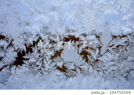 Frost patterns on frozen glass of winter window. Frost patterns on frozen glass of winter window. 104750509