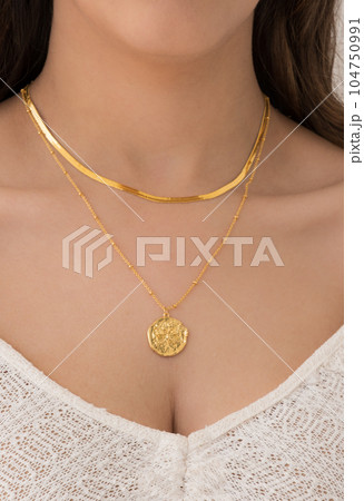 Young woman wearing a butterfly and a snake chain necklace. Young woman wearing a butterfly and a snake chain necklace. 104750991