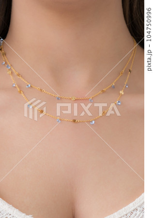 Young woman wearing a double layered necklace. Young woman wearing a double layered necklace. 104750996