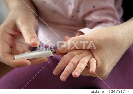 Mother use Nail Trimmer with baby hand. Mom cutting tiny fingernails. Baby care concept. How to successfully clip your baby's nails. Closeup. Newborn hygiene. Clipping Child's Nails. Front view. Mother use Nail Trimmer with baby hand. Mom cutting tiny fingernails. Baby care concept. How to successfully clip your baby's nails. Closeup. Newborn hygiene. Clipping Child's Nails. Front view. 104751718