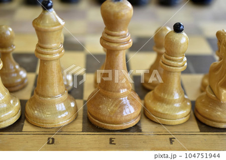 Chess pieces on the board. Wooden chess pieces. Chess pieces on the board. Wooden chess pieces. 104751944