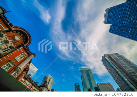 日本の東京都市景観 梅雨の晴れ間。雲間から見える青空（迫る暗雲）と東京駅やビル群などを望む＝7月6日 104752216