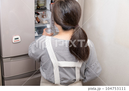 【冷蔵室を物色する主婦】 104753111