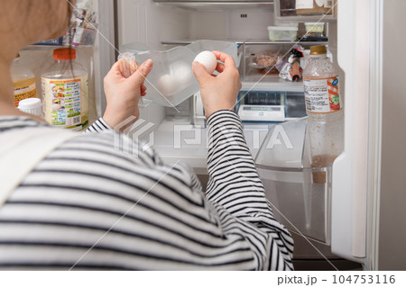 【冷蔵室からたまごを取り出す主婦】 【冷蔵室からたまごを取り出す主婦】 104753116