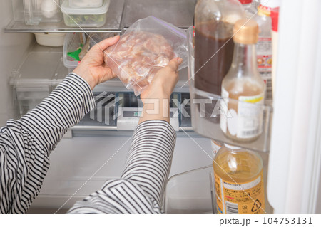 【冷蔵室から唐揚用の下味を付けた鶏肉を出す主婦】 【冷蔵室から唐揚用の下味を付けた鶏肉を出す主婦】 104753131
