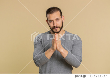 Man praying, looking upward, making wish, asking with hopeful imploring expression, begging apology Man praying, looking upward, making wish, asking with hopeful imploring expression, begging apology 104754937