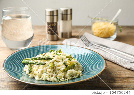 Delicious risotto with asparagus served on wooden table 104756244