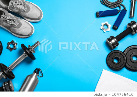 Gym equipment on light blue background, flat lay. Space for text 104756416