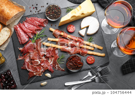 Tasty prosciutto served on grey table, flat lay Tasty prosciutto served on grey table, flat lay 104756444