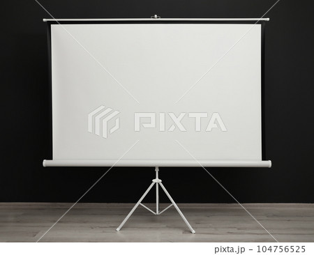 Blank projection screen near black wall indoors. Space for design Blank projection screen near black wall indoors. Space for design 104756525