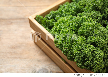 Fresh kale leaves on wooden table, closeup Fresh kale leaves on wooden table, closeup 104756546
