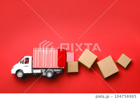 Top view of toy truck with boxes on red background. Logistics and wholesale concept 104756985